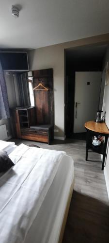 a bedroom with a large white bed and a table at Hotel Crasborn Thorn in Thorn