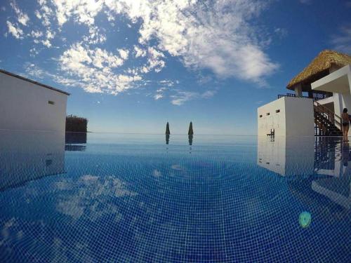 a swimming pool with a view of the ocean at Hotel Maya Jade in Monterrico