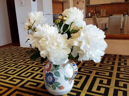 a vase filled with white flowers on a table at Jasmine Residence in Prejmer