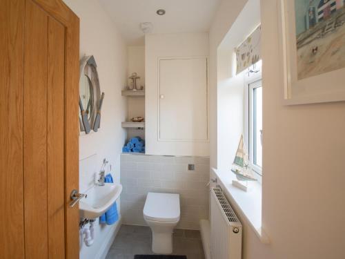 a bathroom with a white toilet and a sink at Lemonade Cottage in Whitby
