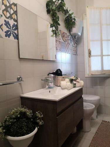 a bathroom with a sink and a toilet and a mirror at Il Pastore Serafino in Tropea