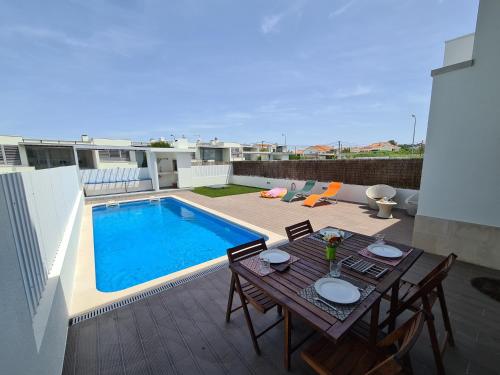 a patio with a table and a swimming pool at Meco Beach Villa in Sesimbra