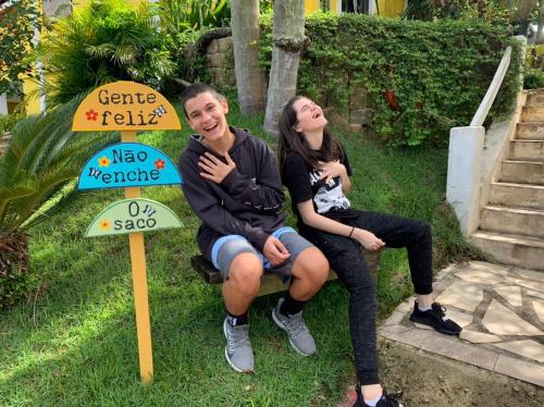 a man and a woman sitting next to a sign at Vila Lia in São Sebastião