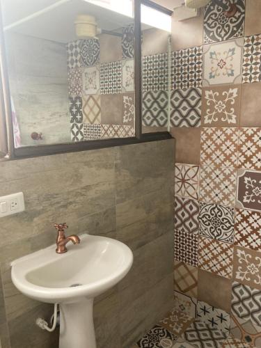 y baño con lavabo y espejo. en Hostal CasAlé Usaquén en Bogotá