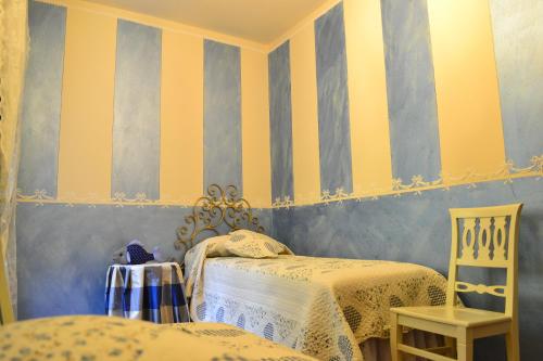 a bedroom with two beds and yellow and blue stripes at Relais De La Place in Desenzano del Garda