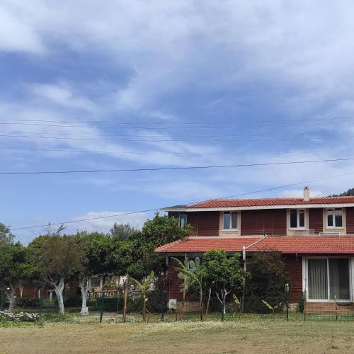 a red house with trees in front of it at Esin's Houses in Marmaris