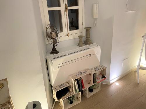 a room with a white wall with a shelf and a mirror at No 14 Cádiz in Cádiz