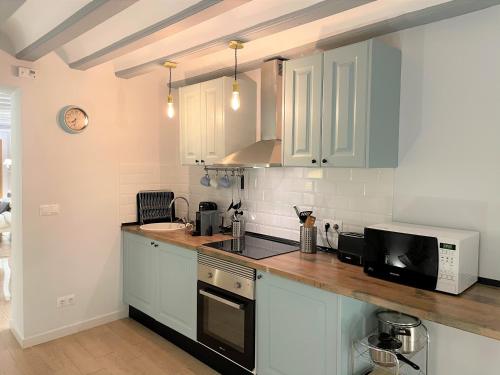 a kitchen with white cabinets and a microwave at No 14 Cádiz in Cádiz
