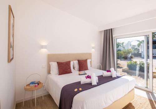 a bedroom with a large bed and a large window at Villa Benagil Boutique by Algarve Vacation in Carvoeiro