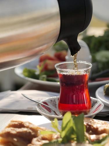 una persona che versa la salsa in una tazza di cibo di Sahil Martı Hotel a Mezitli