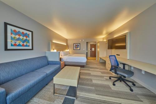 a hotel room with a couch and a bed at Holiday Inn Express & Suites - Hermiston Downtown by IHG in Hermiston