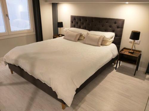 een groot bed met witte lakens en kussens in een slaapkamer bij No 38 Cádiz in Cádiz