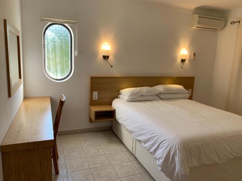 a bedroom with a bed and a desk and a window at Villa Tara Christina in Carvoeiro