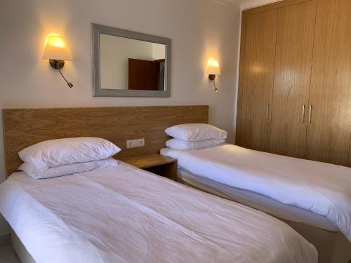 a hotel room with two beds and a mirror at Villa Tara Christina in Carvoeiro