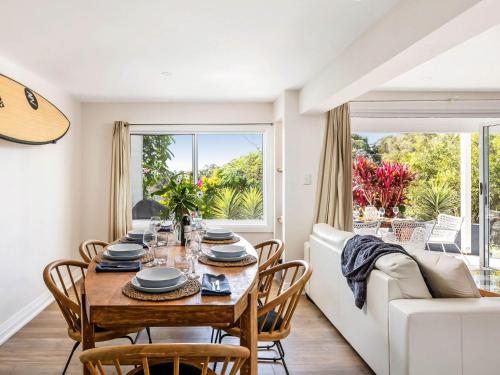 a dining room with a table and chairs and a couch at Blue View Gerringong in Gerringong