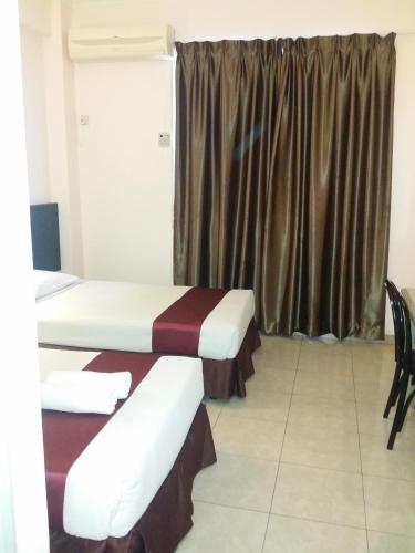 a hotel room with two beds and a window at Seremban Inn in Seremban