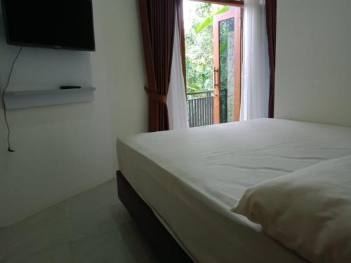 ジョグジャカルタにあるVilla Lavender Purba Viewのベッドルーム1室(ベッド1台、壁掛けテレビ付)