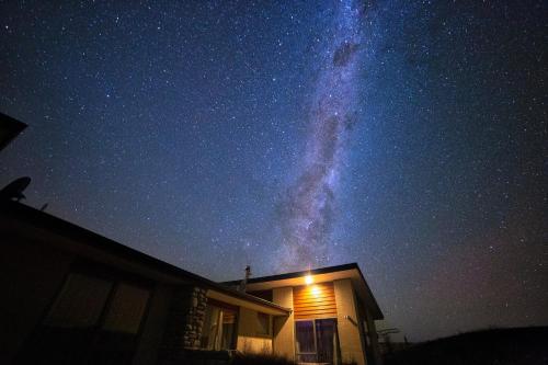 a night sky with a house and the milky way at Hillcrest Lodge A - Lake Tekapo in Lake Tekapo
