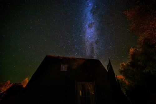 a house under a starry sky with the milky way at Fox Chalet - Lake Tekapo in Lake Tekapo