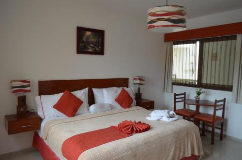 1 dormitorio con 1 cama con manta roja y mesa en Hotel Real Mercedes en Mérida