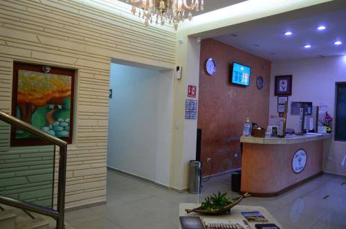 a lobby with a door and a counter with clocks at Hotel Real Mercedes in Mérida