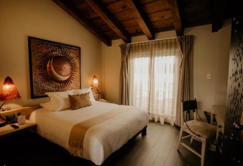Un dormitorio con una cama grande y una ventana en Plaza Gallery Hotel Boutique, en San Cristóbal de Las Casas