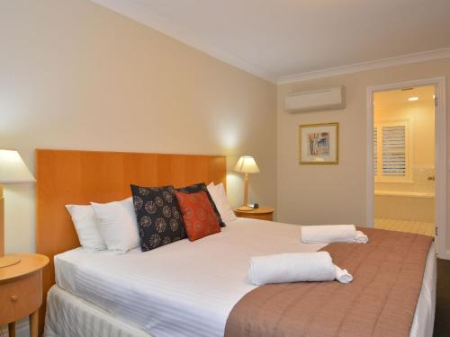 a bedroom with a large bed with two pillows at Villa 3br De Saran located within Cypress Lakes Resort in Pokolbin