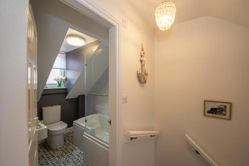 a bathroom with a toilet and a glass shower door at Estuary View in Whitby
