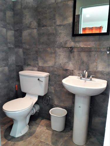 a bathroom with a toilet and a sink at Miller's Guest House in Buccoo