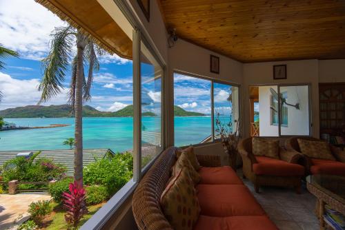 a screened in porch with a view of the ocean at Colibri Hotel in Baie Sainte Anne