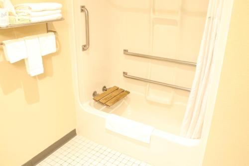 a bathroom with a tub with towels and a shower at Days Inn by Wyndham Black River Falls - Access to ATV Trail in Black River Falls