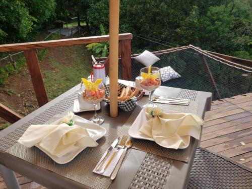 a table with plates and utensils on a patio at Eco-Glamping Shalom in Mariquita