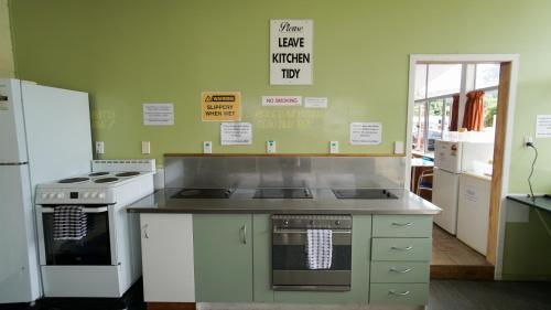 a kitchen with a stove and a refrigerator at Whangarei Central Holiday Park in Whangarei