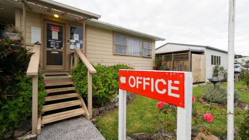 a house with a coffee sign in front of it at Whangarei Central Holiday Park in Whangarei