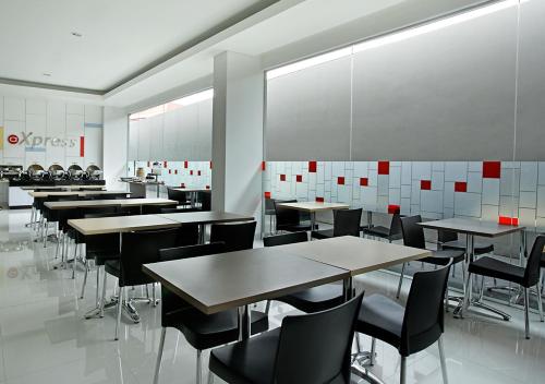 a dining room with tables and chairs in a restaurant at Amaris Hotel Juanda in Jakarta