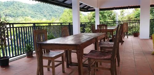 a wooden table and chairs on a porch at Khmer House Guesthouse in Kep