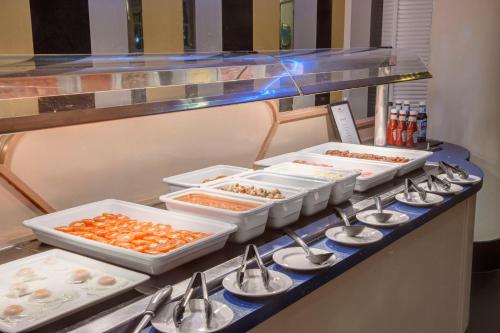 a buffet line with several trays of food on it at Crowne Plaza Liverpool - John Lennon Airport by IHG in Liverpool