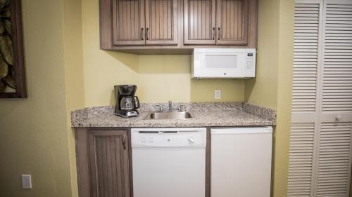 a small kitchen with a sink and a microwave at Holiday Inn Club Vacations Cape Canaveral Beach Resort in Cape Canaveral