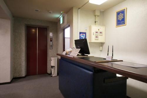 an office with a desk with a computer on it at Heiwadai Hotel Arato in Fukuoka