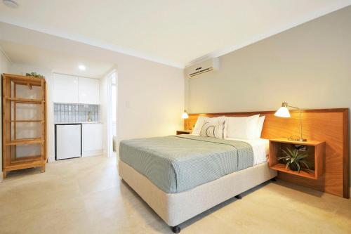 a bedroom with a large bed and a kitchen at Bay of Palms in Gold Coast