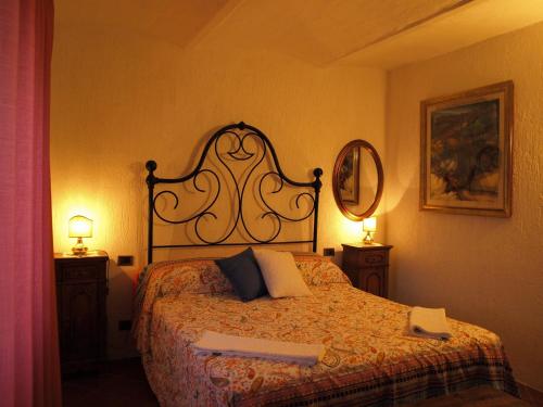 a bedroom with a bed with two lamps and a mirror at Agriturismo Podere 3 Querce in Manciano
