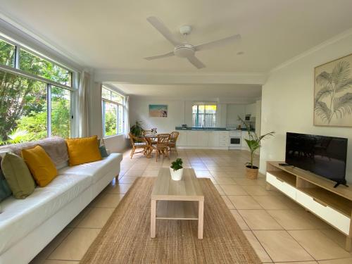 a living room with a couch and a tv at Tree Escape in Rainbow Beach