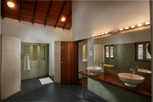 a bathroom with two sinks and a large mirror at The Beach Villas by Ceylon Bungalows in Wadduwa