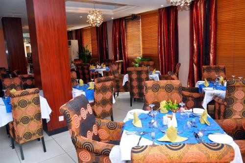 een eetkamer met tafels en stoelen met een blauw tafelkleed bij Room in Lodge - Golden Tulip Port Harcourt Hotel in Port Harcourt