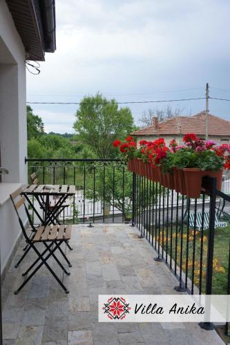 a balcony with a table and flowers on a fence at Villa Anika in Mezek