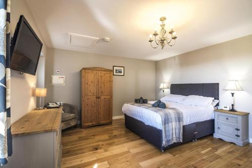 Schlafzimmer mit einem Bett und einem Flachbild-TV in der Unterkunft The Beacon - 3 Bedroom Cottage - Ludchurch - Narberth in Ludchurch