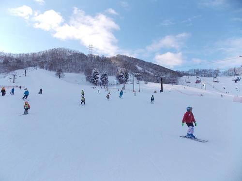 a group of people skiing down a snow covered slope at Granbell hotel Tanuki, Sapporo in Sapporo
