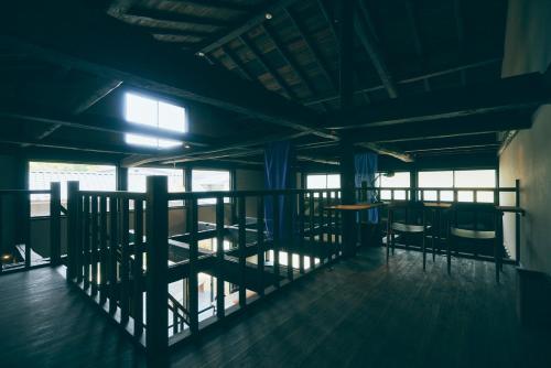 a room with a balcony with chairs and a table at Kominkayado LOOF Shikinoie in Ōtsuki