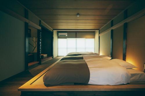 a large bed in a room with a window at Kominkayado LOOF Shikinoie in Ōtsuki