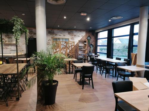 - un restaurant avec des tables, des chaises et de grandes fenêtres dans l'établissement le Ricordeau, à Domagné